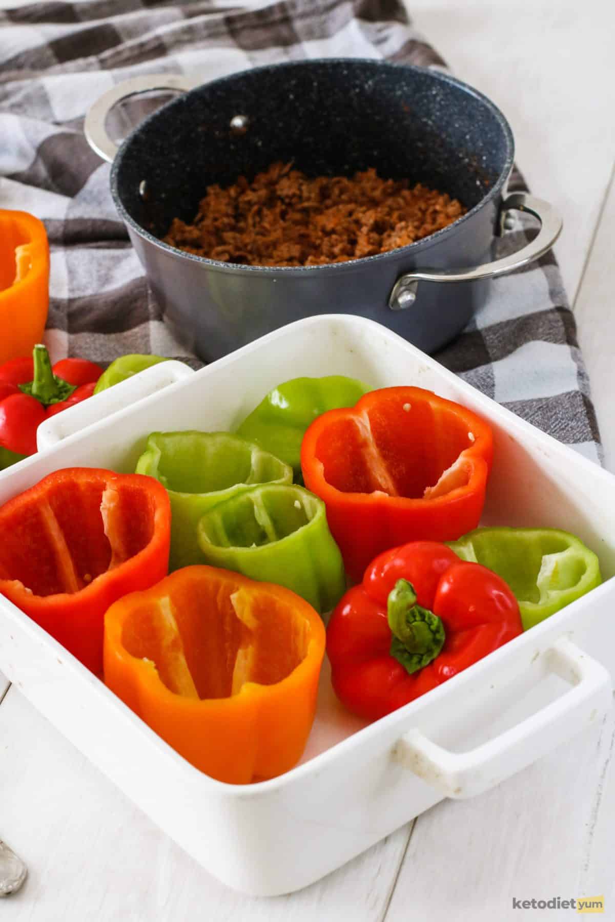 Bell pepper cups arranged in a baking pan ready to add ground beef and cauliflower filling