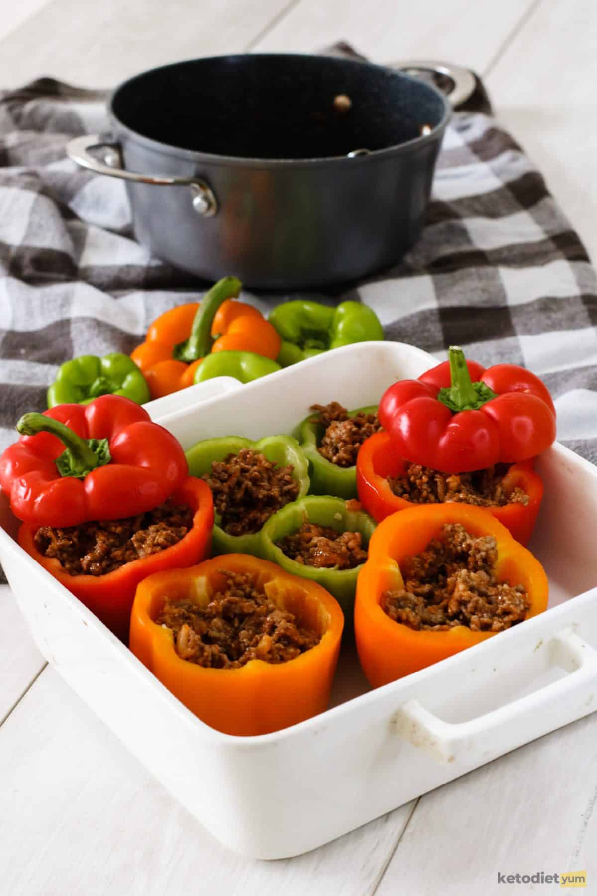Halved bell peppers in a baking pan filled with ground beef and cauliflower mixture