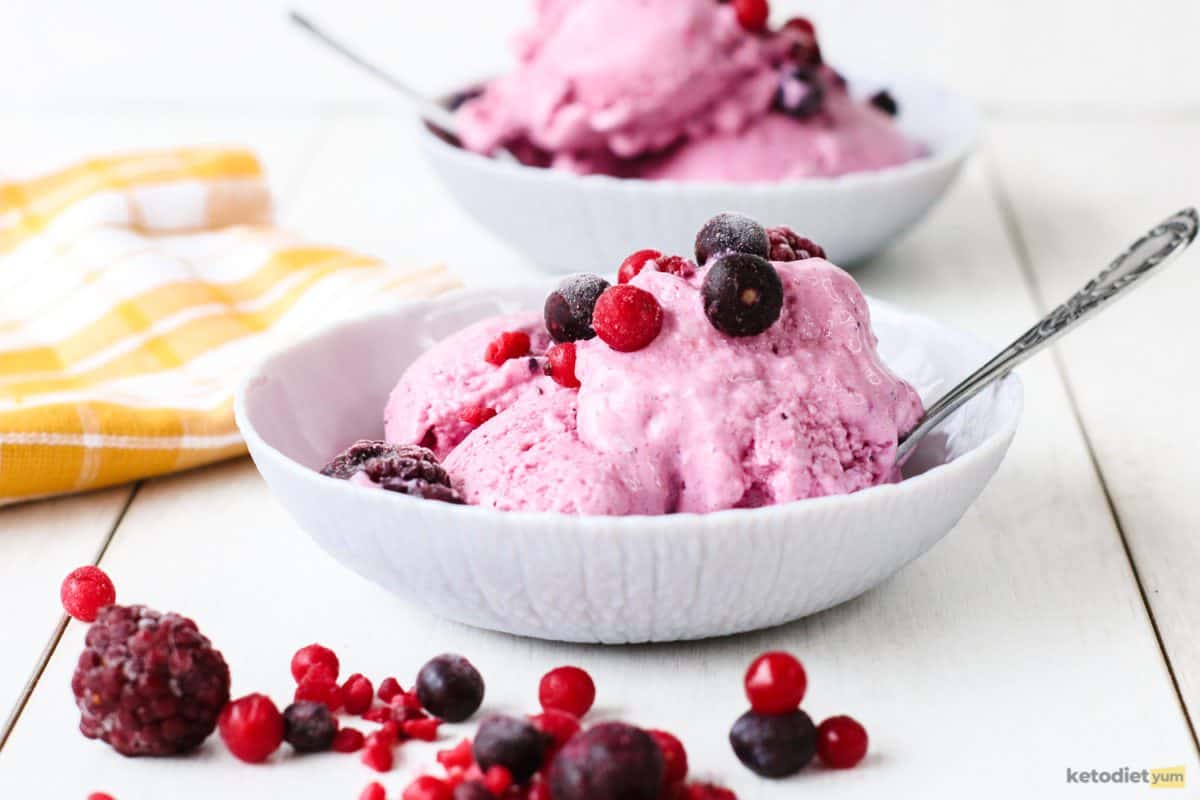 Sugar free frozen yogurt topped with frozen fruit and served in a white bowl