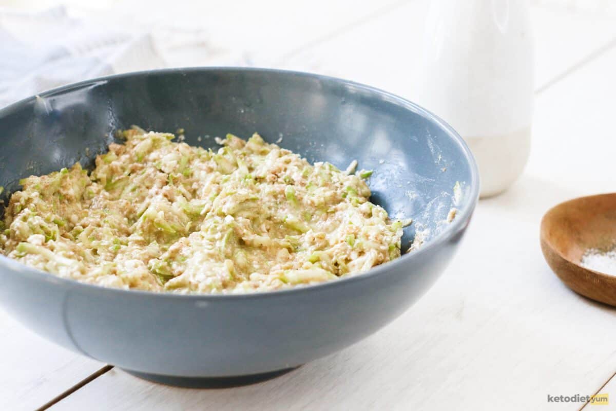 Grated zucchini, almond flour and hard cheese mixture ready to make keto zucchini fritters