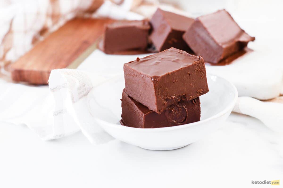 Slices of sugar free keto chocolate fudge made with peanut butter in a white bowl