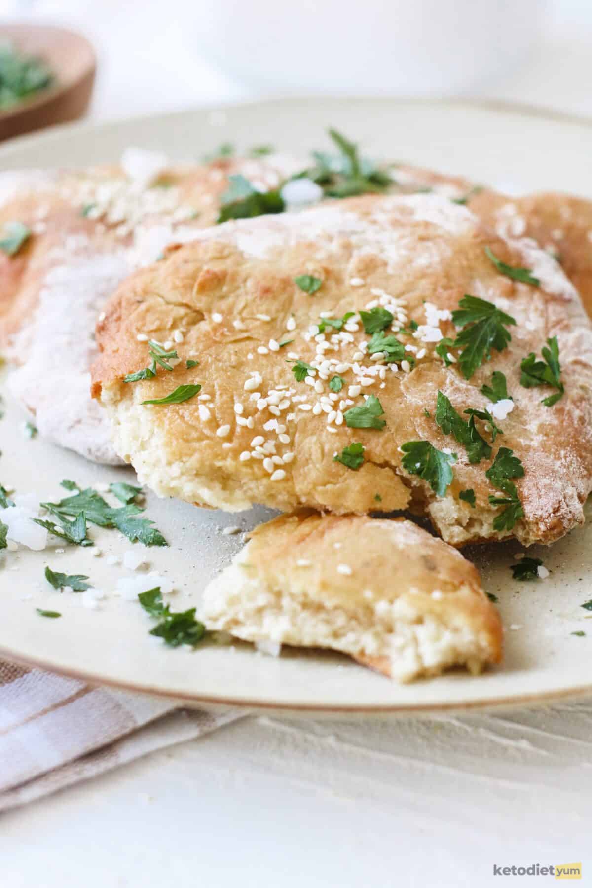 Delicious low carb naan bread brushed with olive oil and sprinkled with sea salt, sesame seeds and chopped parsley