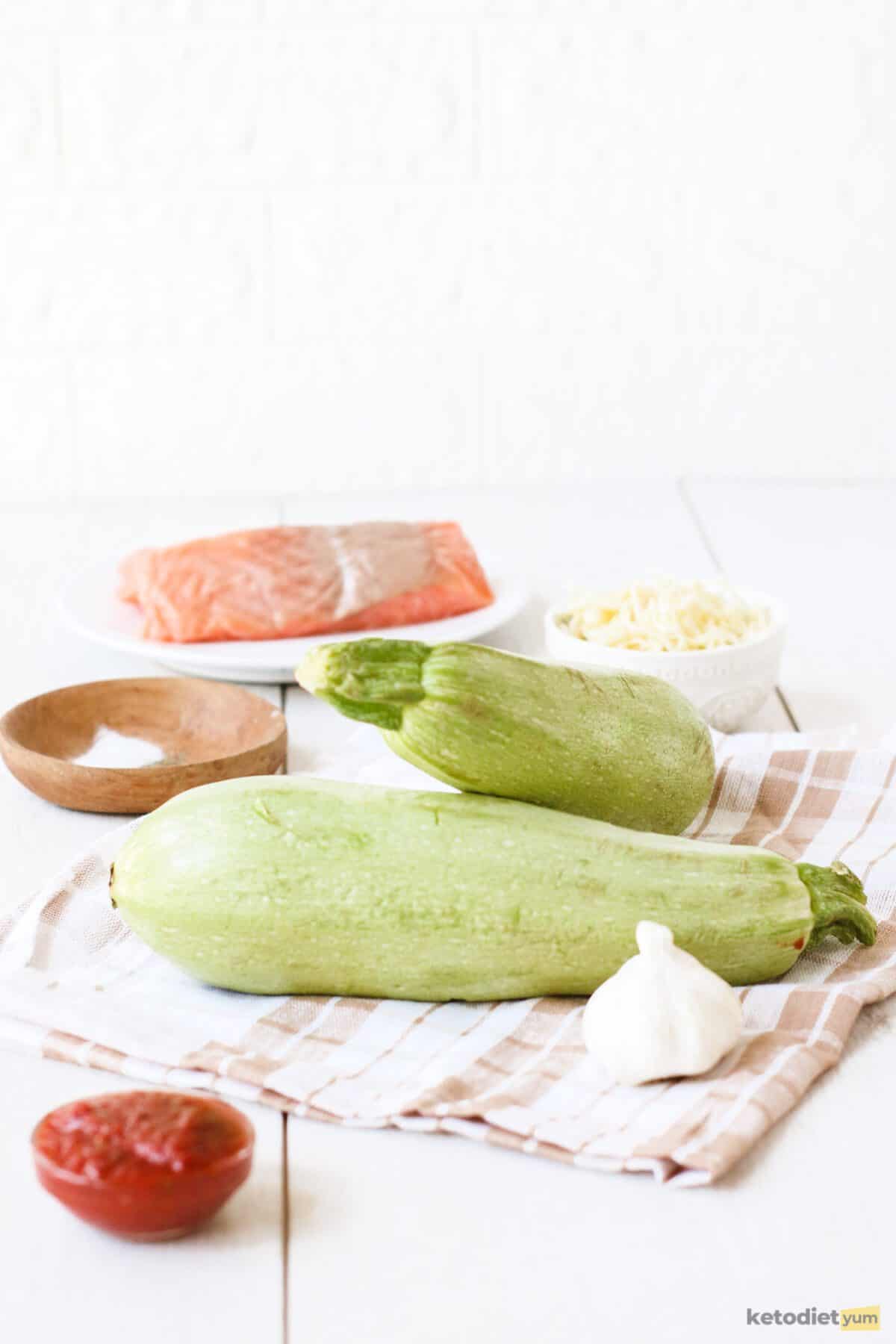 Ingredients arranged on a table to make keto salmon stuffed zucchini boats