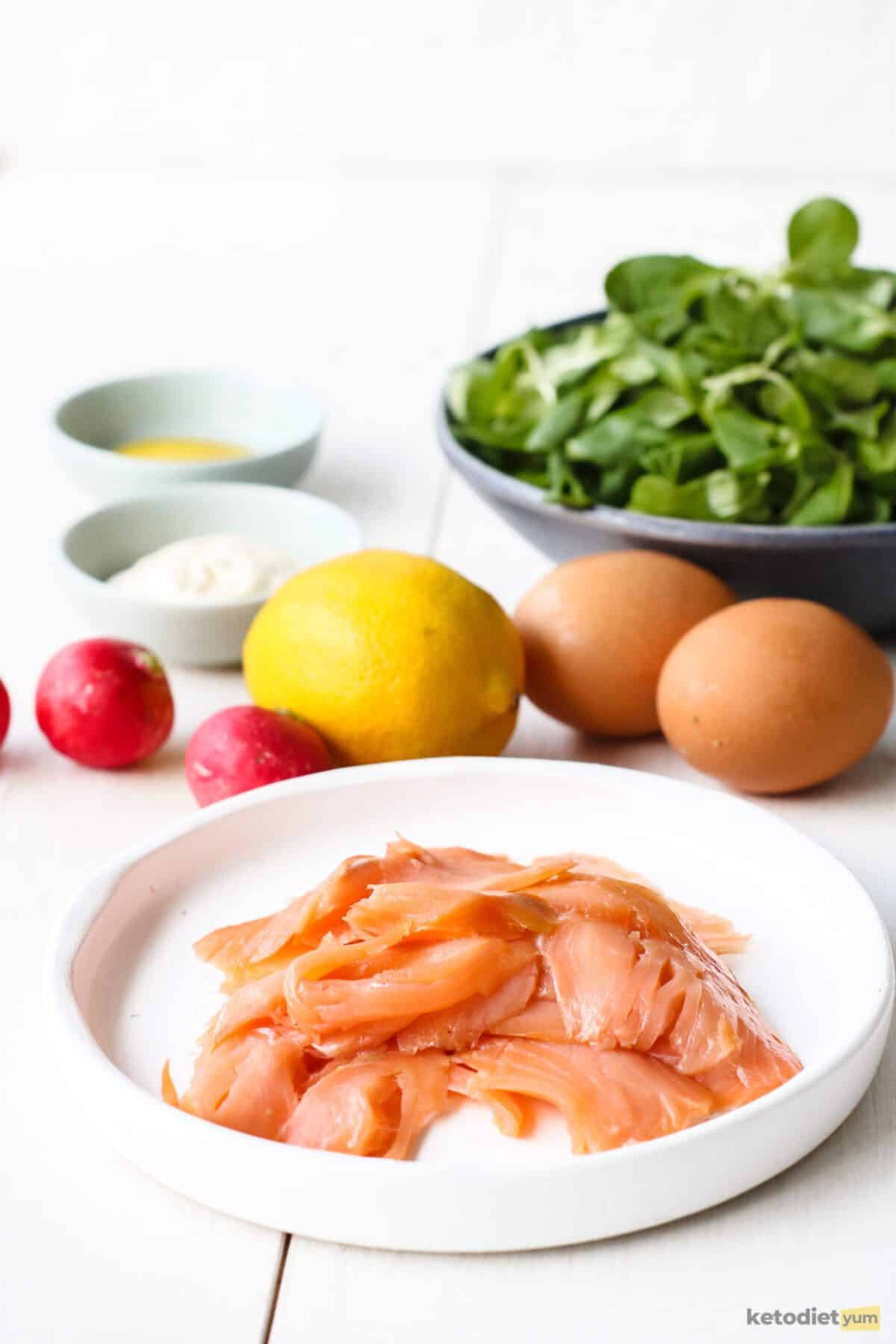 Ingredients arranged on a table needed to make a low carb smoked salmon with valerian and radish salad