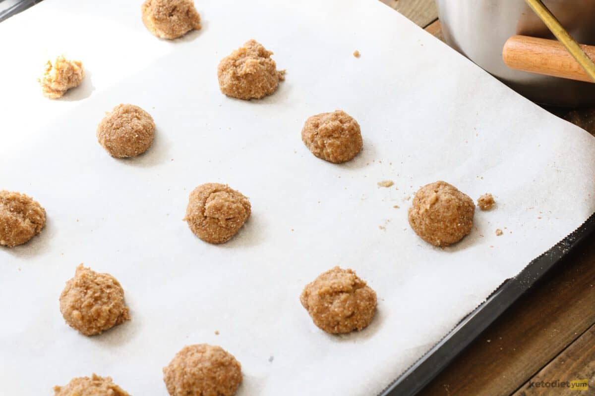 Keto donut holes arranged on a lined baking pan ready to bake