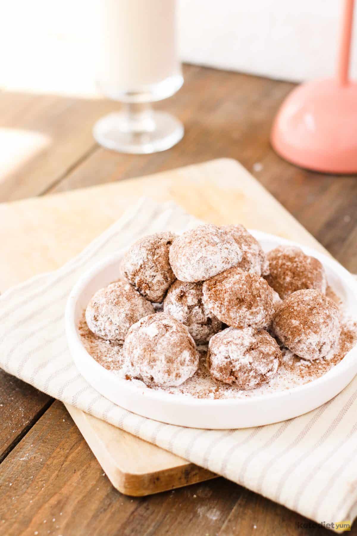 Keto donut holes on a plate coated with a cinnamon sugar coating