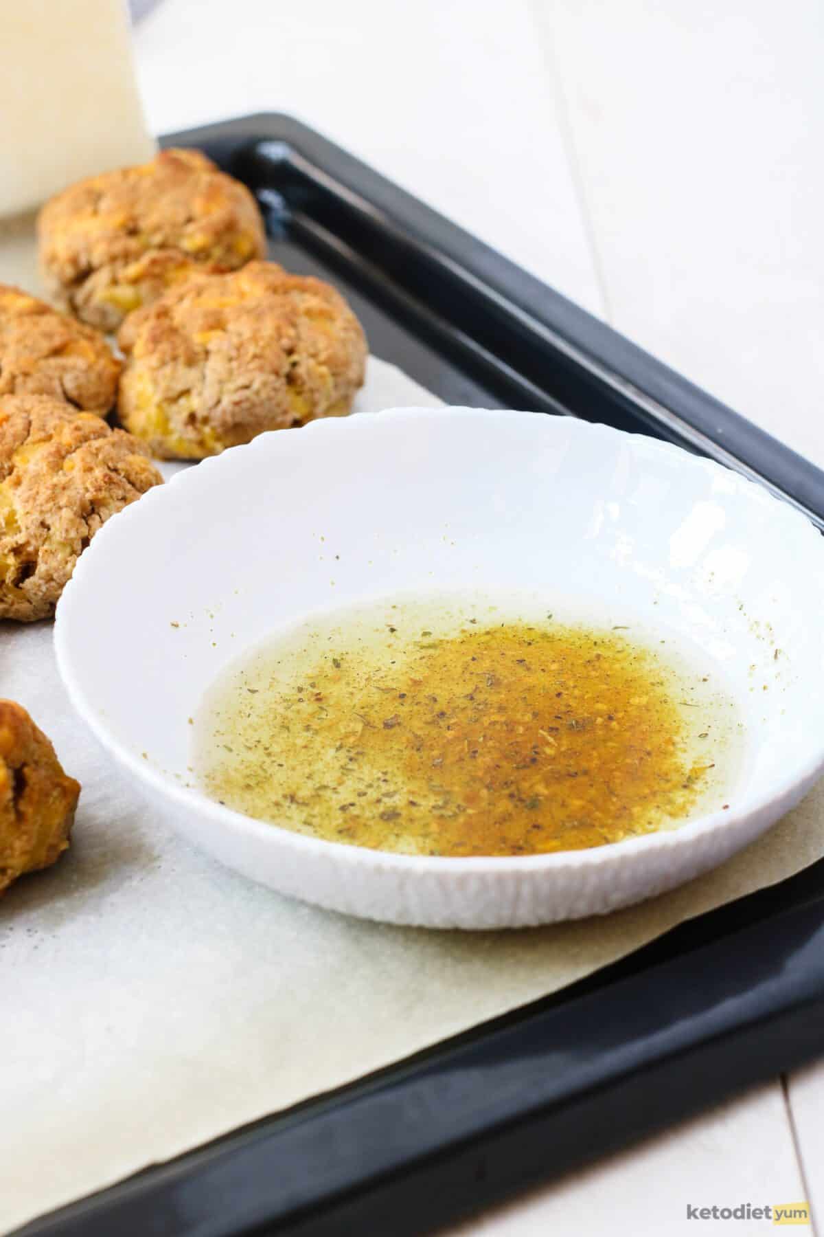 Low carb cheddar biscuit coating made with melted butter, garlic powder and salt ready to brush on the cheddar biscuits