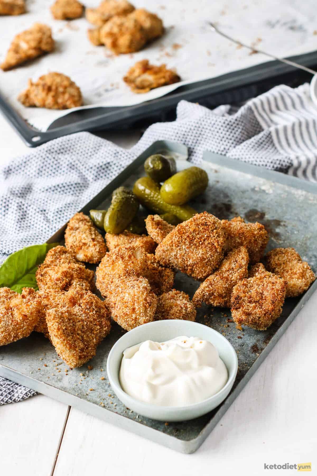 Perfectly golden keto chicken nuggets served with mayonnaise and dill pickles
