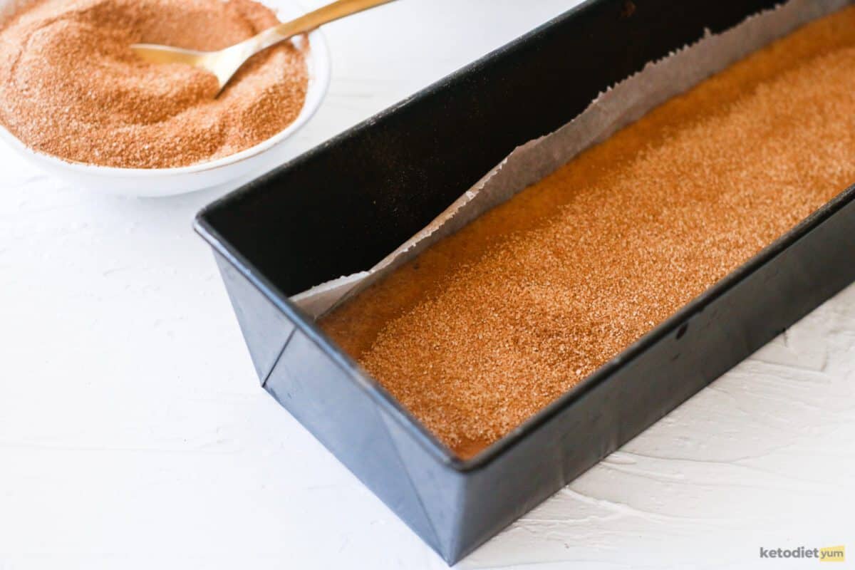 Batter poured into a lined loaf pan and topped with cinnamon swirl mixture