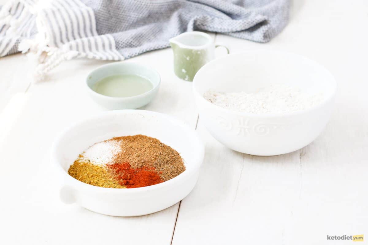 Ingredients arranged on a table to make keto Doritos including almond flour, sunflower oil, xanthan gum, protein powder and seasonings