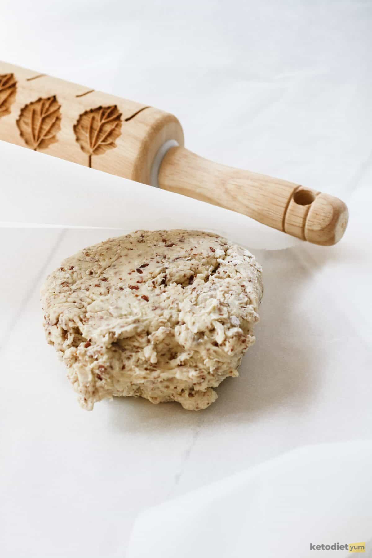 Low carb Dorito dough placed in between two sheets of baking paper to roll into a thin dough