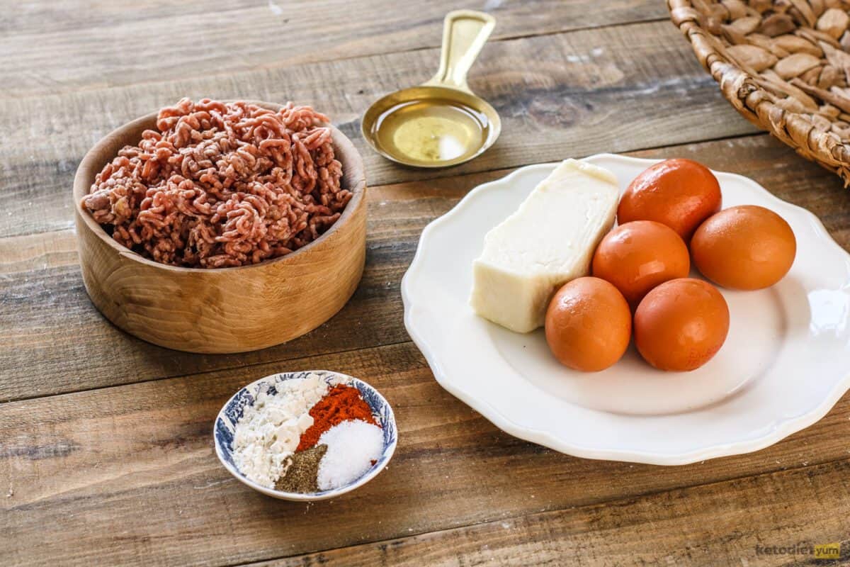 Keto Scotch Eggs Ingredients arranged on a table to make keto Scotch eggs including ground pork, eggs, almond flour, sunflower oil, smoked paprika, salt and black pepper