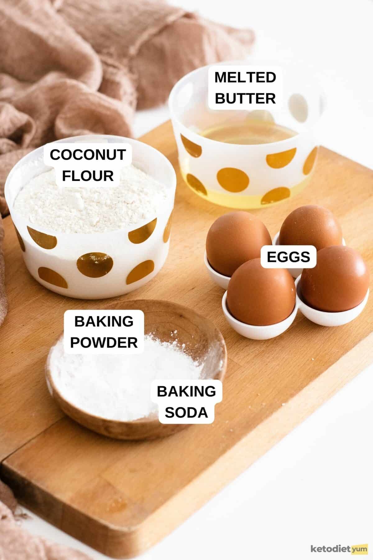 Four eggs and three bowl on a chopping board on a white table