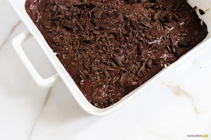 Baking pan with avocado brownie sprinkled with dark chocolate ready to bake