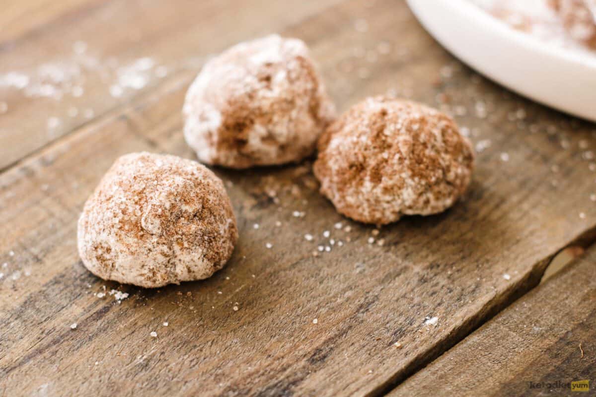 Three donut holes with cinnamon-sugar coating on a table