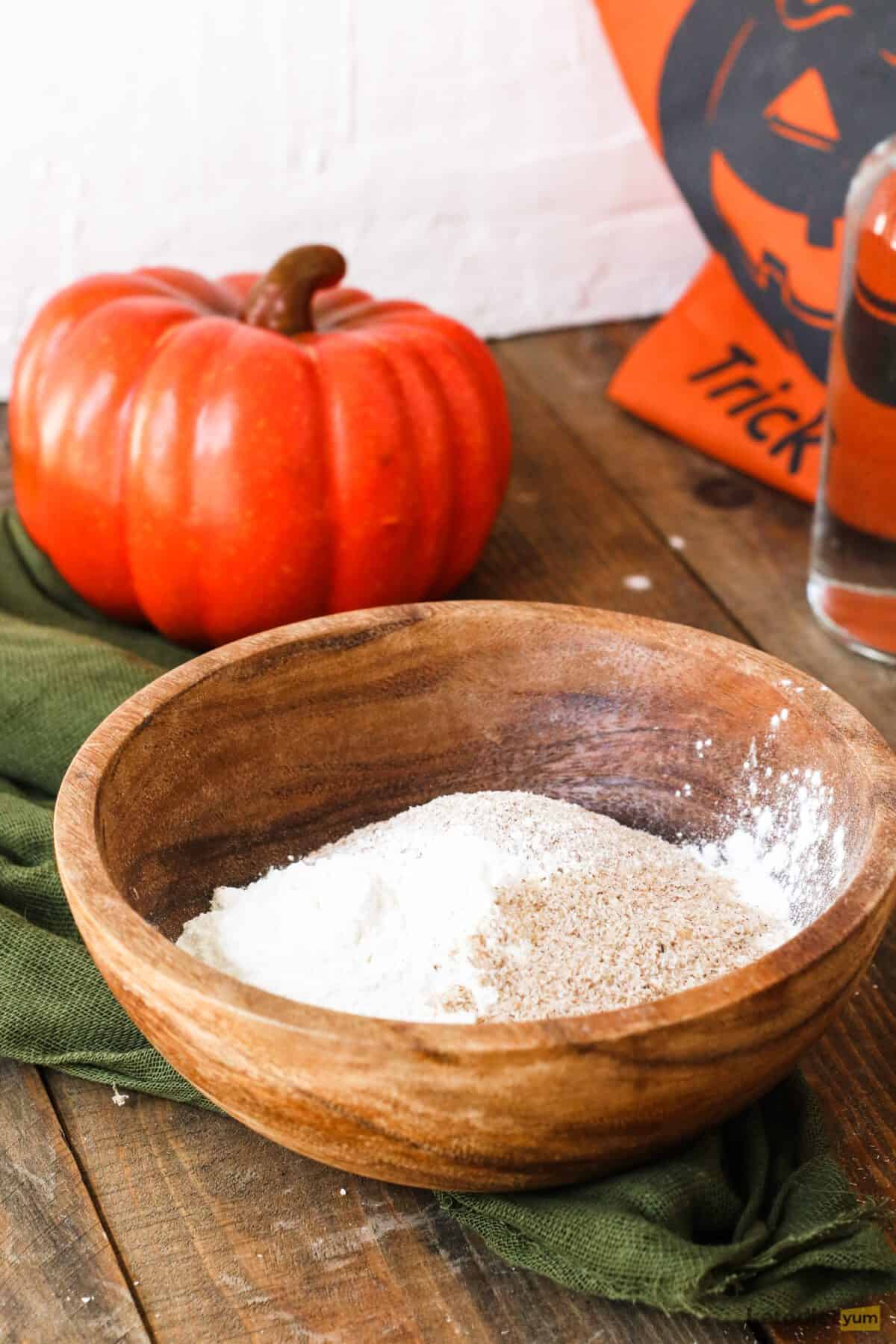 Brown bowl on a table with a decorative pumpkin in the background