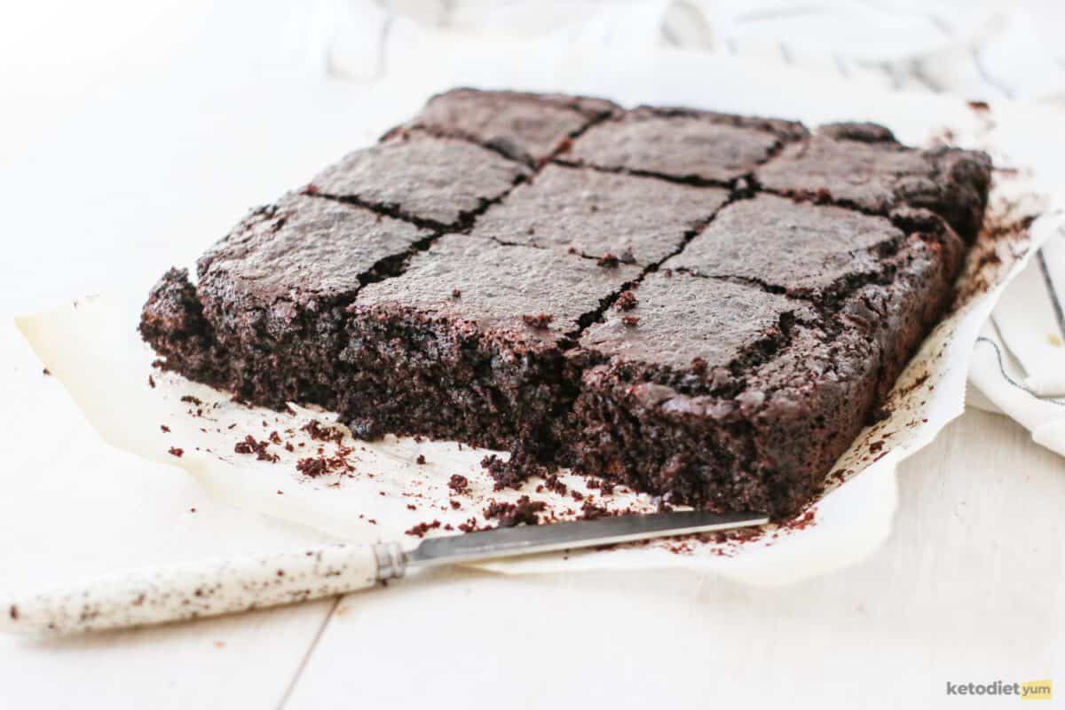 Sliced brownie squares on baking paper with a knife