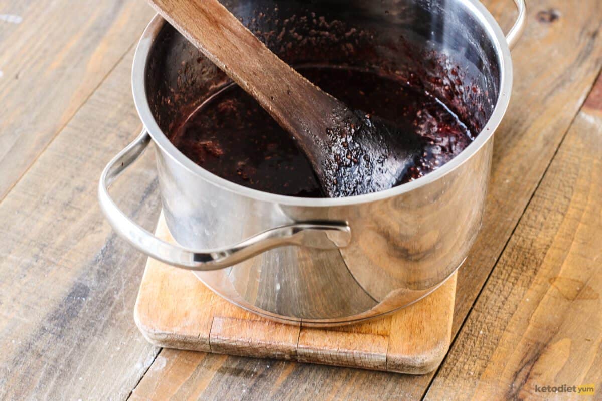 Sugar-free raspberry chia seed jam cooling in a saucepan