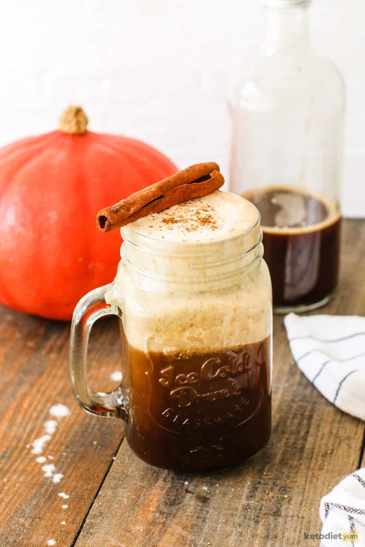 Starbucks pumpkin cream cold brew in a glass topped with pumpkin cream and garnished with pumpkin spice and a cinnamon stick