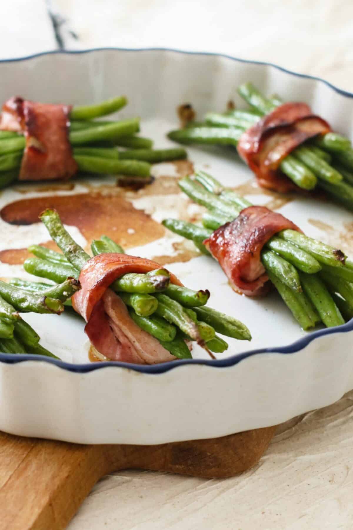 Bacon wrapped green beans baked to perfection in a baking dish