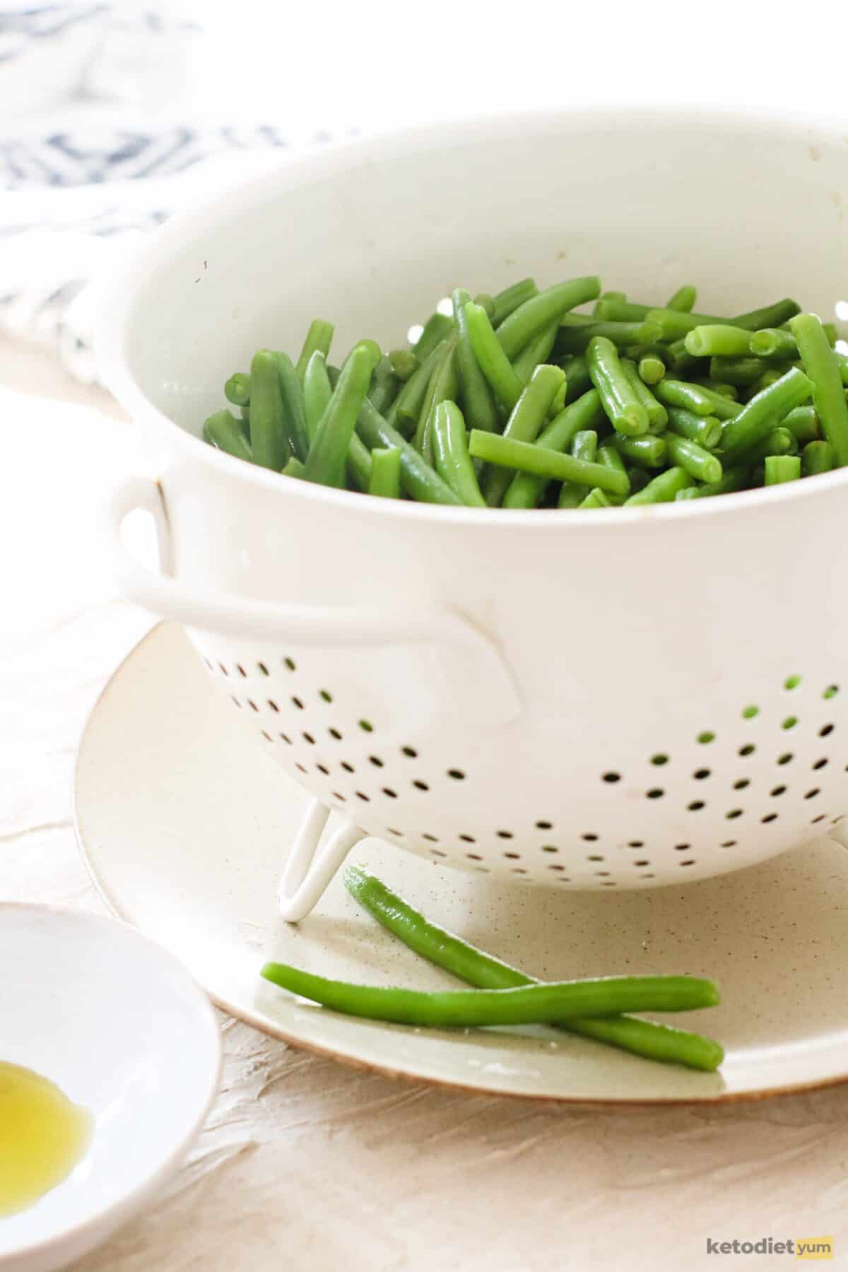 Green beans in a colander sitting on a plate