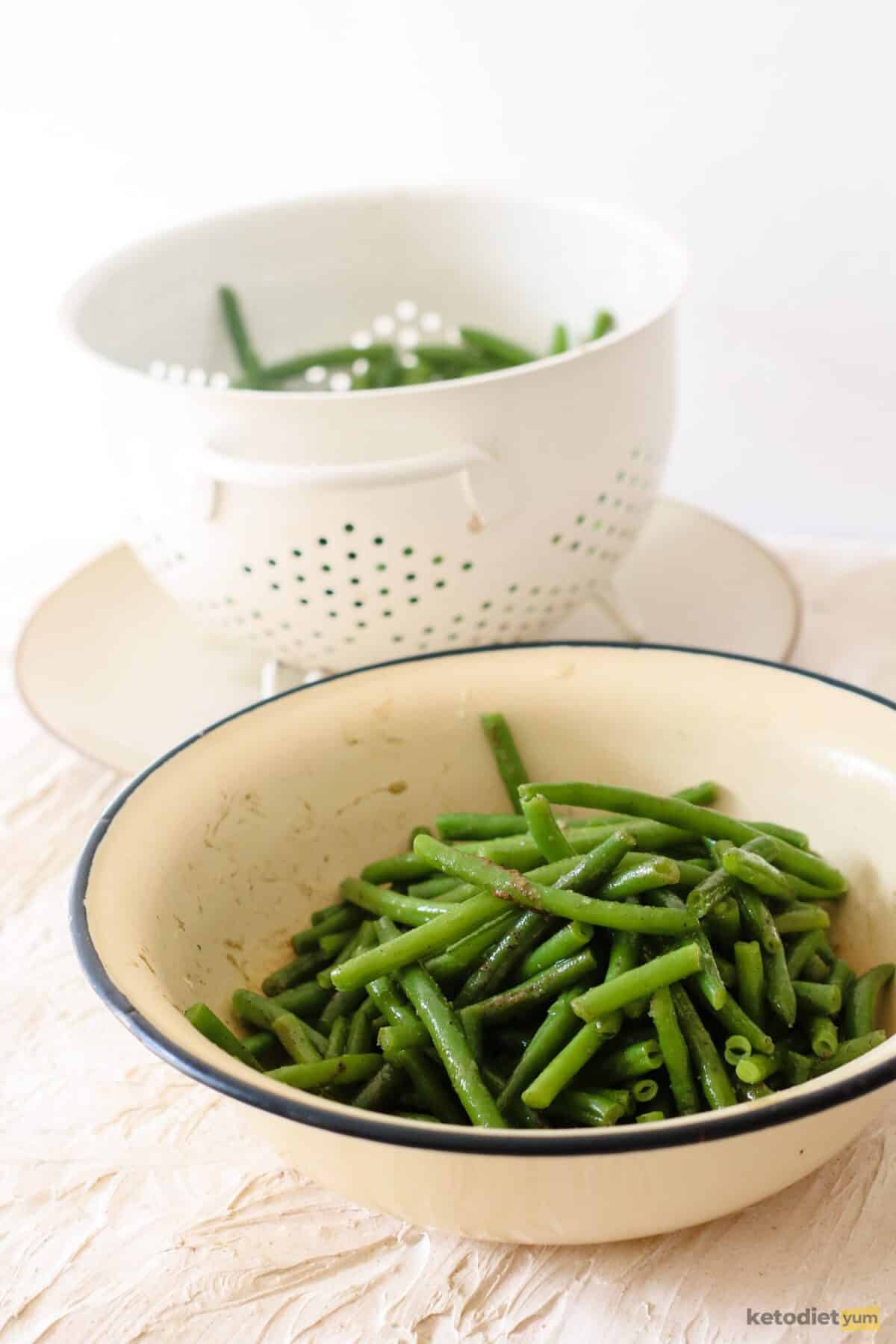 Green beans in a bowl mixed with butter and seasoned with garlic powder, salt and black pepper