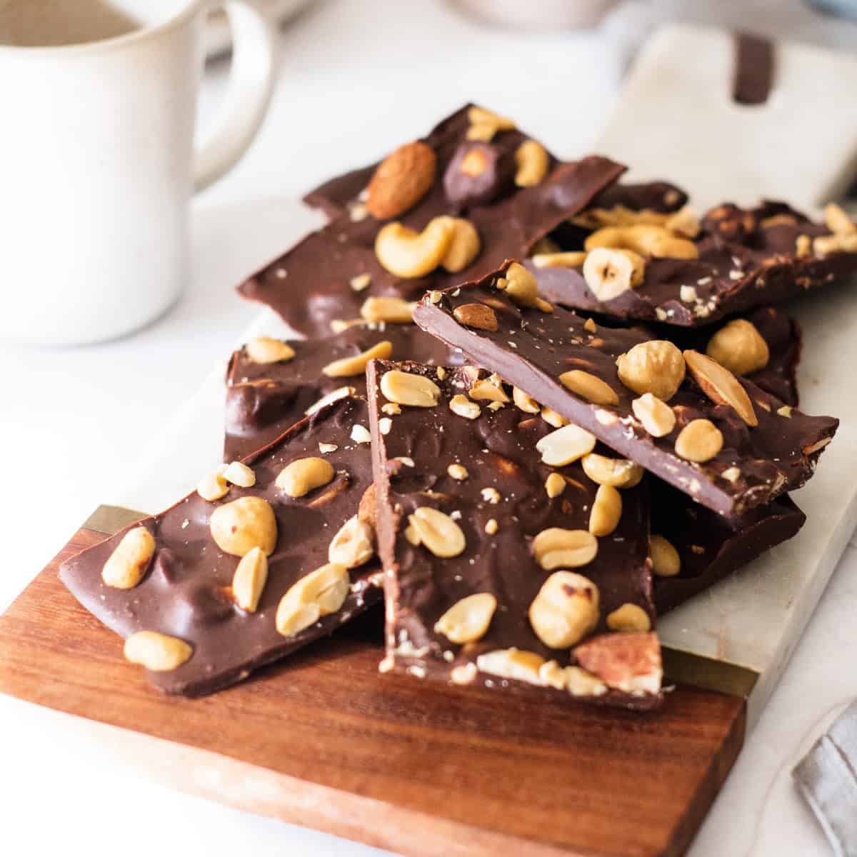 12 Best Keto Snacks (And 4 You Must Avoid) to Lose Weight Chocolate bark with nuts and nuts on a cutting board