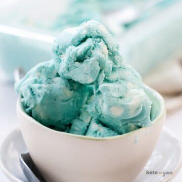 a bowl of keto blue moon ice cream with a spoon on a table