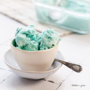 a bowl of keto blue moon ice cream with a spoon on a table