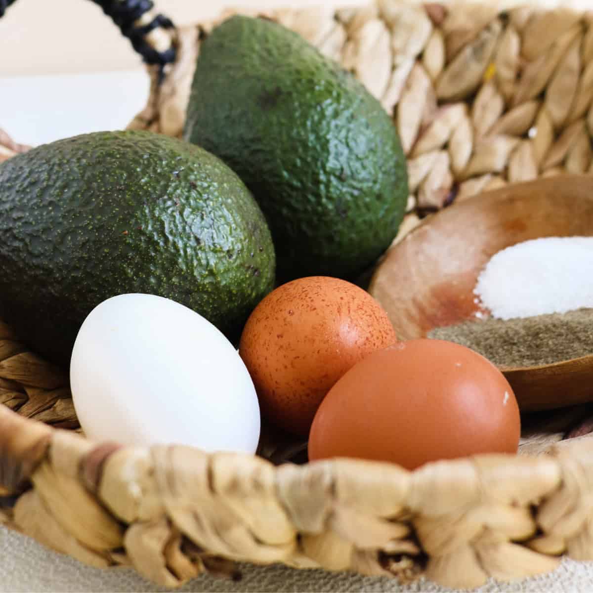Fresh eggs and avocados in a kitchen basket